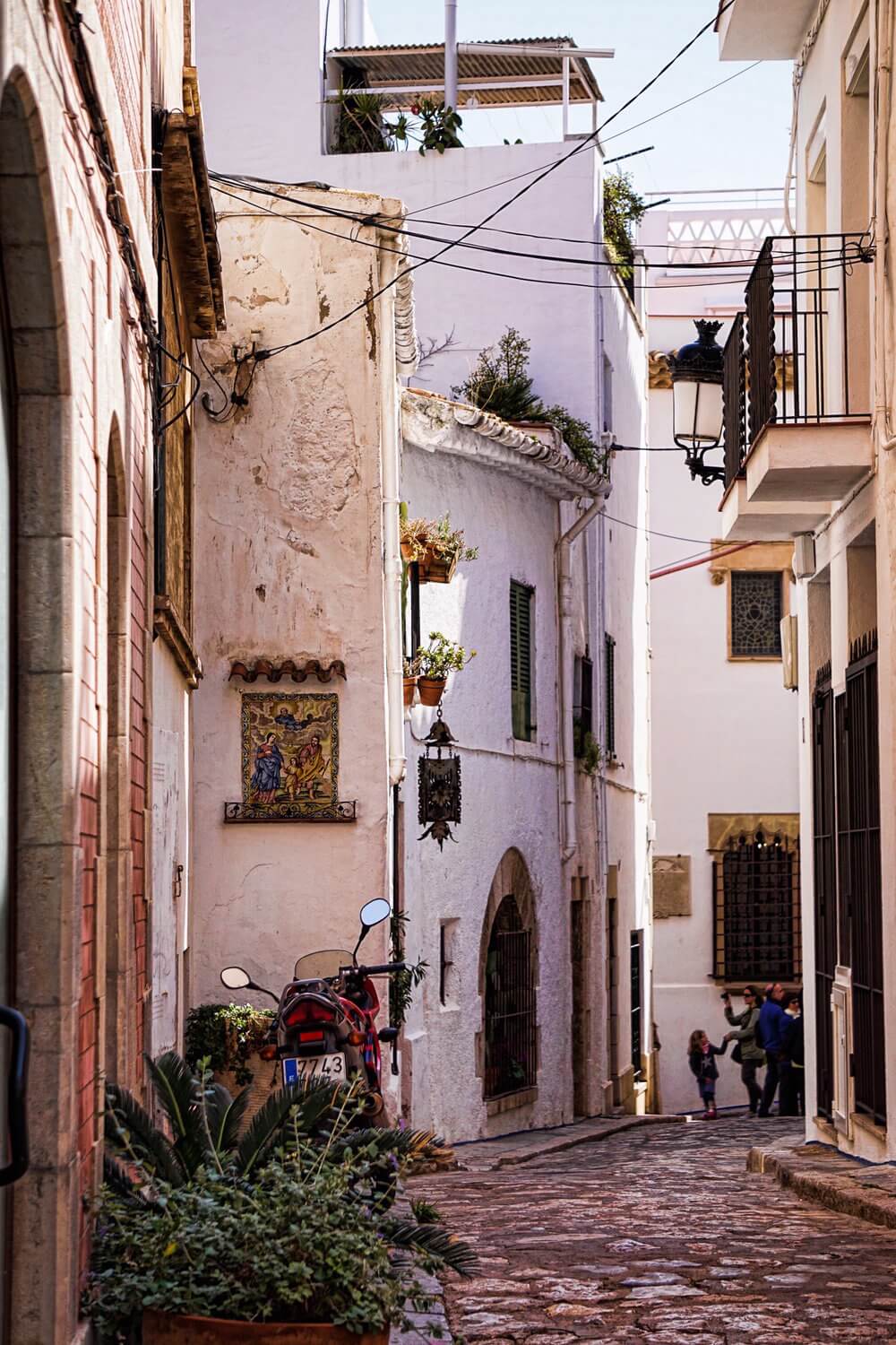 What to do in Sitges: wander a narrow medieval street with whitewashed buildings