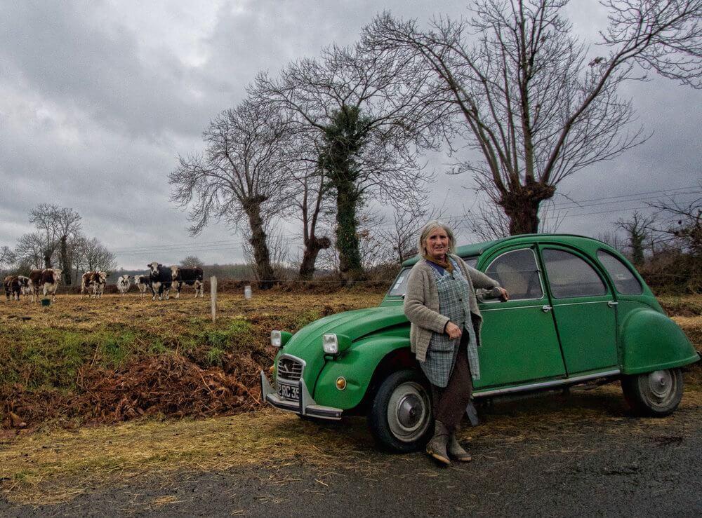 Woman leaning on her green citroen in the country