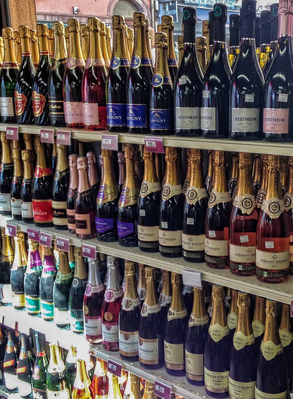 Visit Colmar: Bottles of champagne line the shelves in the grocery store