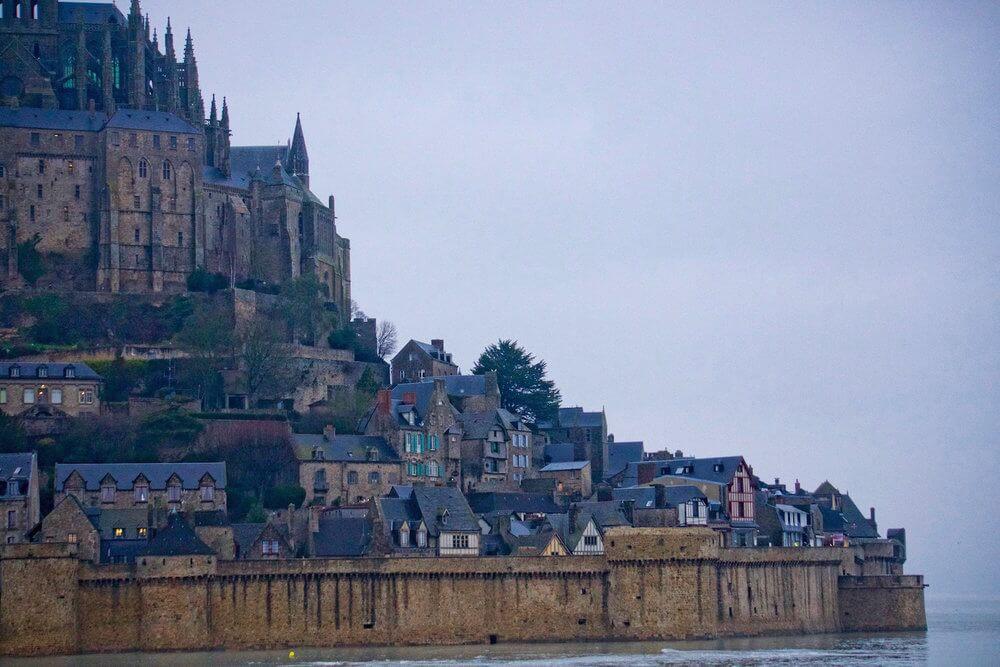 Visiting le Mont-St-Michel the medieval town is tucked under the church contained by the stone wall
