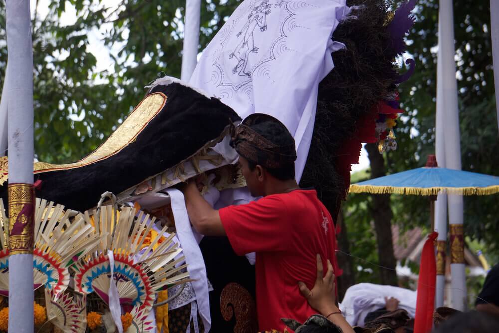 Balinese cremation ceremony: putting personal belongings of the deceased in the ox