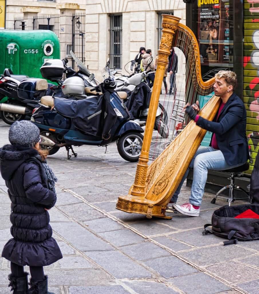 Explore Paris - street musician playing the harp, little girl listening