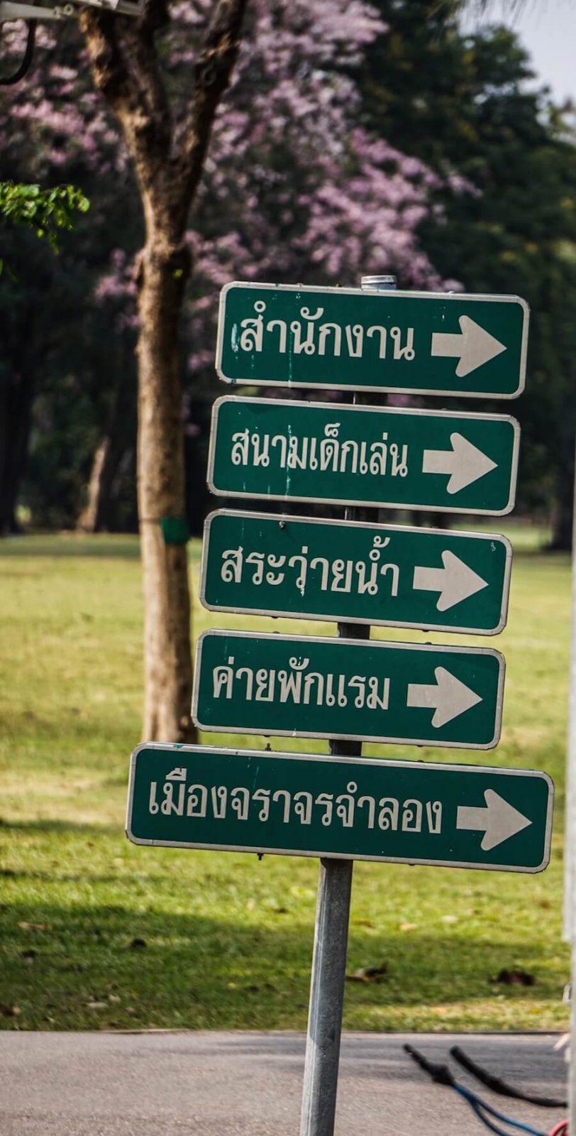 plan my journey: sign post with 5 green signs all pointing in the same direction written in Thai