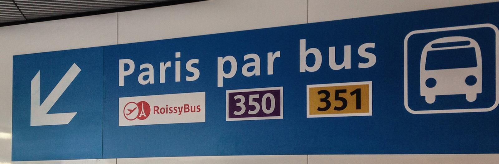 Sign Paris par Bus with a white arrow showing where to catch the bus
