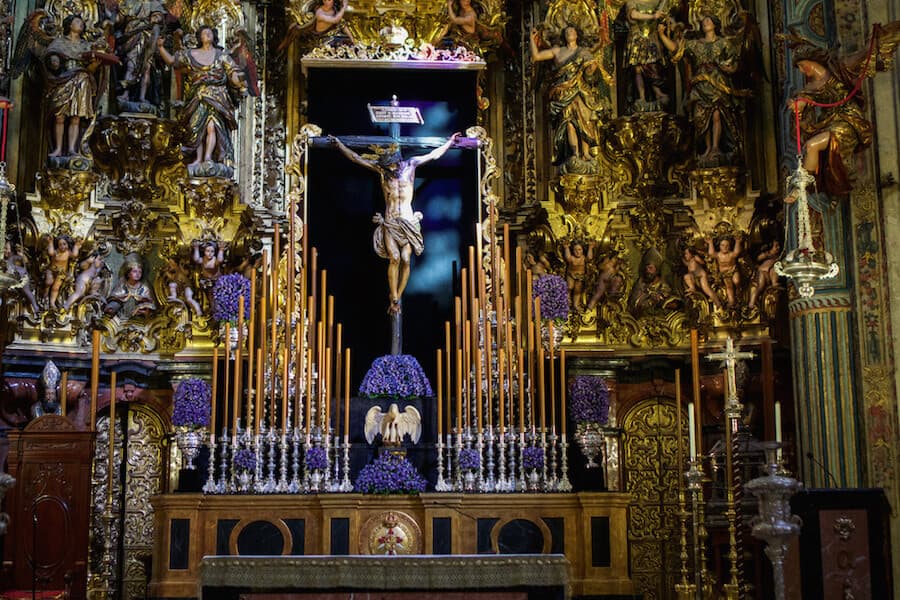 Intricate gold sculptures around the altar with Jesus on the cross