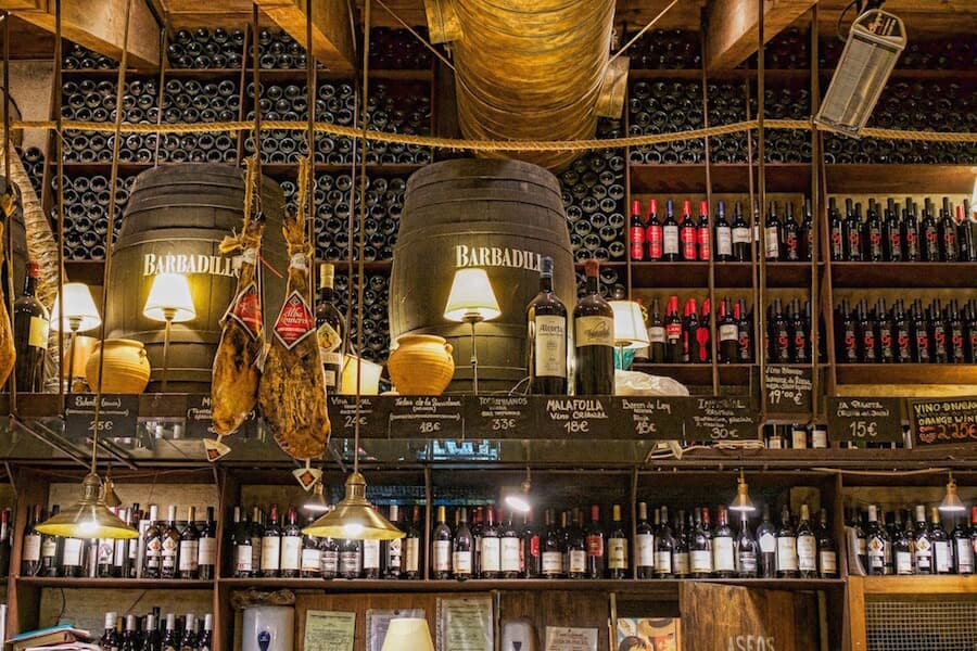 Seville in 2 days: Bottles of wine line the walls, while ham hangs from the ceiling
