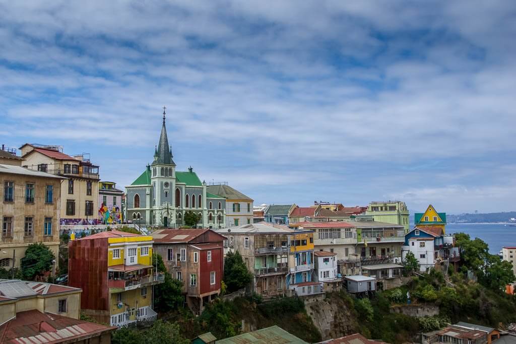 colourful houses and a grey church and spire in Valparaiso Chile