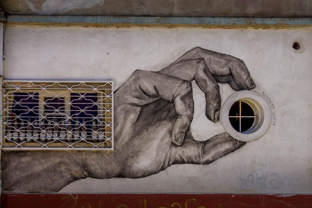 street art - a painted hand holding a circular window