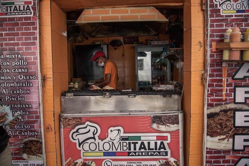 Things to do in Cartagena: eat street food; orange stall with man cooking