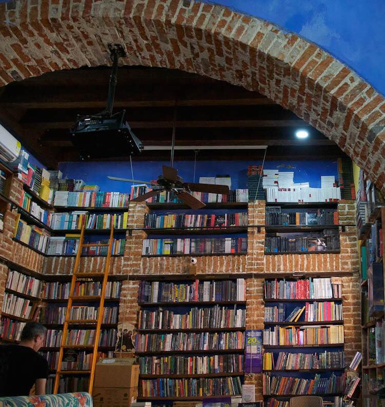 Things to do in Cartagena: visit this cafe with brick bookcases floor to ceiling