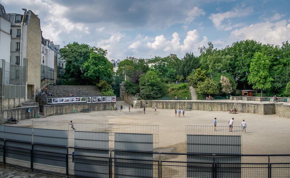 Unique Places in Paris: circular arena surrounded by trees; a few people in the arena