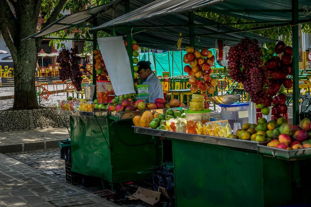 fruit stand selling cut fruit of all colours