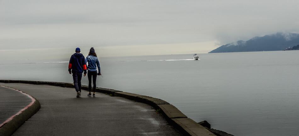 a couple walking away on a misty morning by the sea