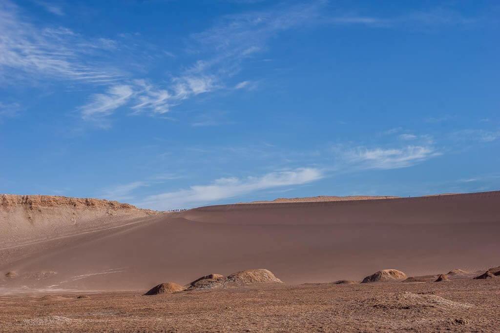 Things to do in San Pedro de Atacama: reddish sand stretching skyward. Specks on top are people