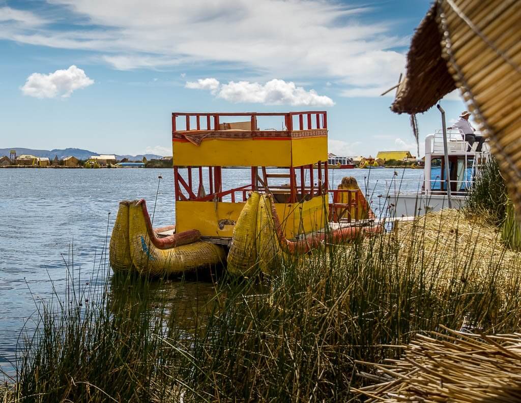 Uros: traditional reed boat with wooden structure to sit in. Bright Yellow with a bit of red trim