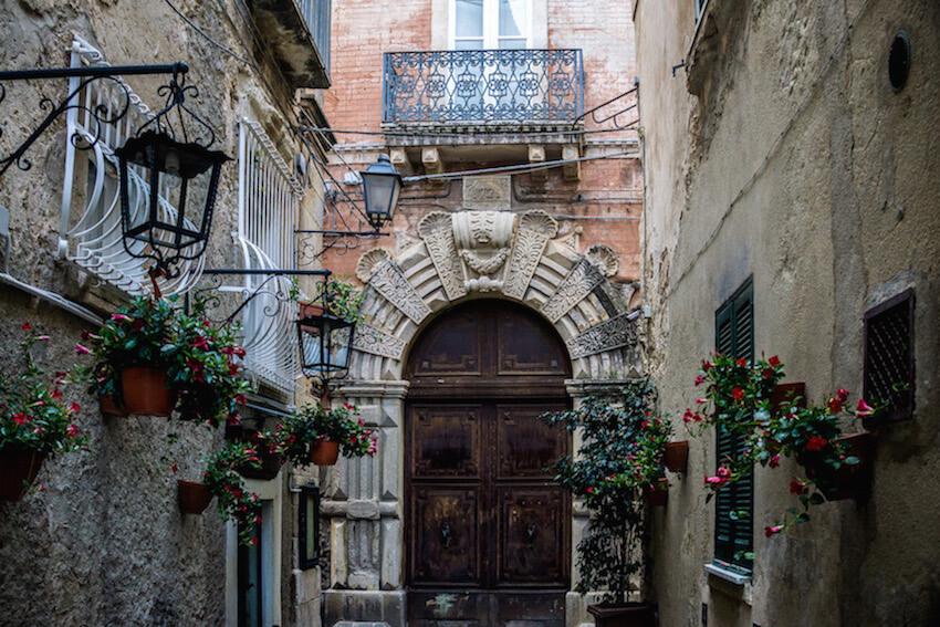 Tropea Calabria - wooden doorway with carved stone archway at the end of the road. 
