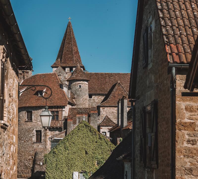 Carennac: a jumble of red stone buildings with the church tower rising from behind the houses