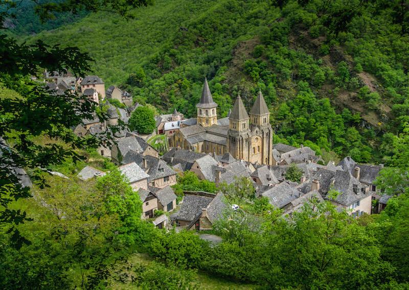 Conques France from above. Slate rooftops and 3 spires soaring towards the sky