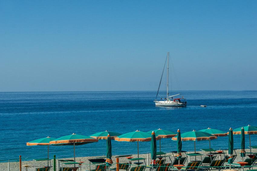 Scilla Calabria: looking out past the beach umbrellas to a sailboat in the sea