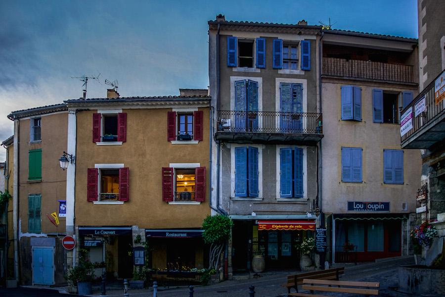 Moustiers-Sainte-Marie France: evening light on tall shuttered buildings