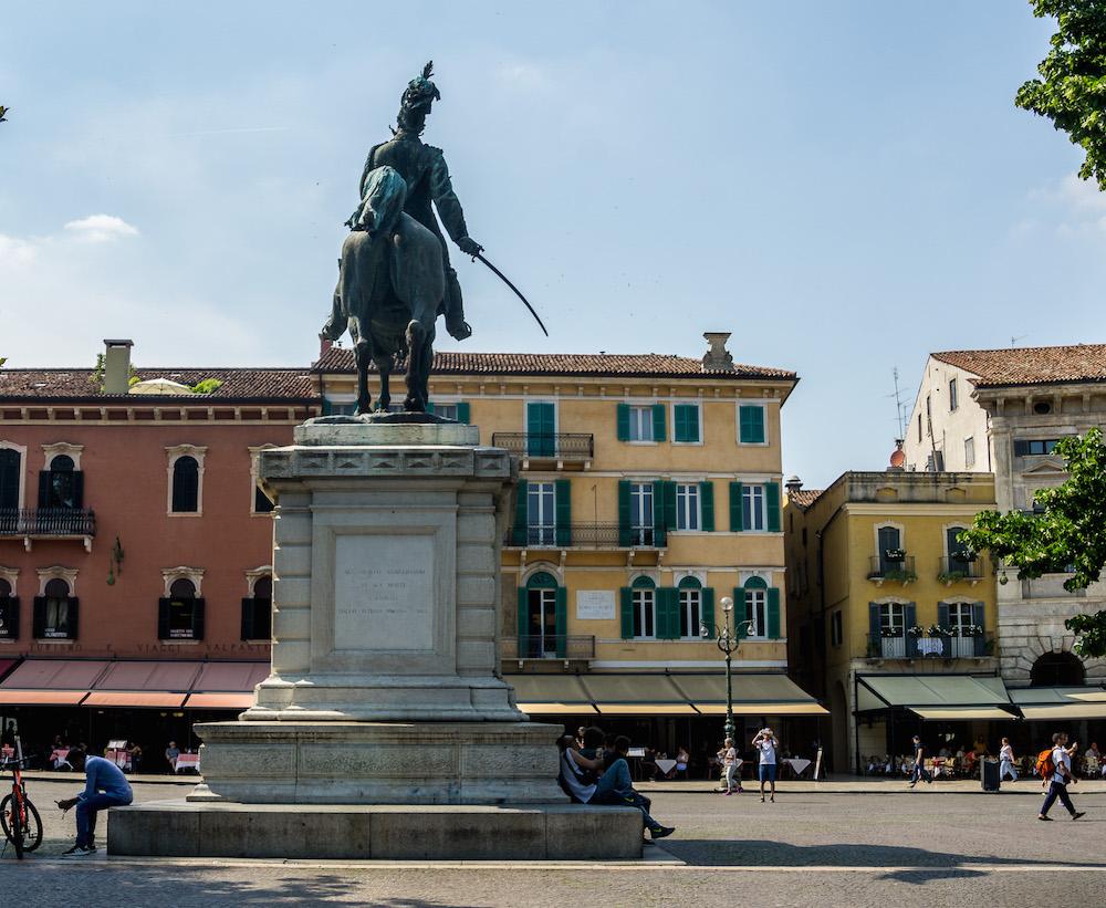 piazza with red and yellow buildings and a statue