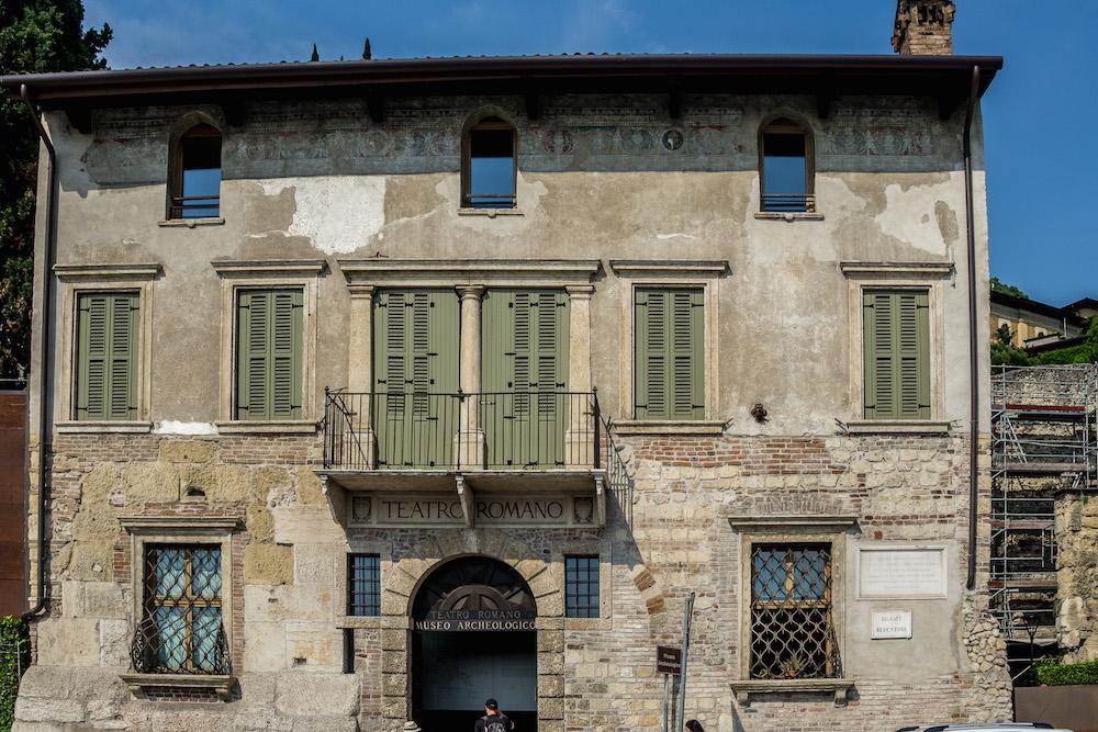 What to see in Verona: gorgeous old facade with sage green shutters and peeling frescoes