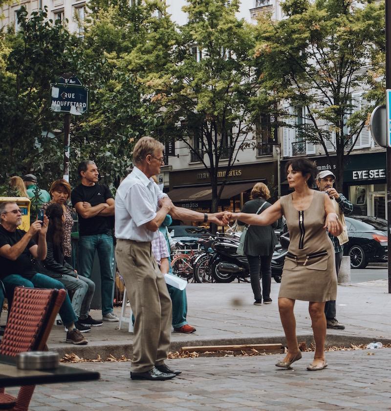 Un bărbat și o femeie dansând pe străzile Parisului