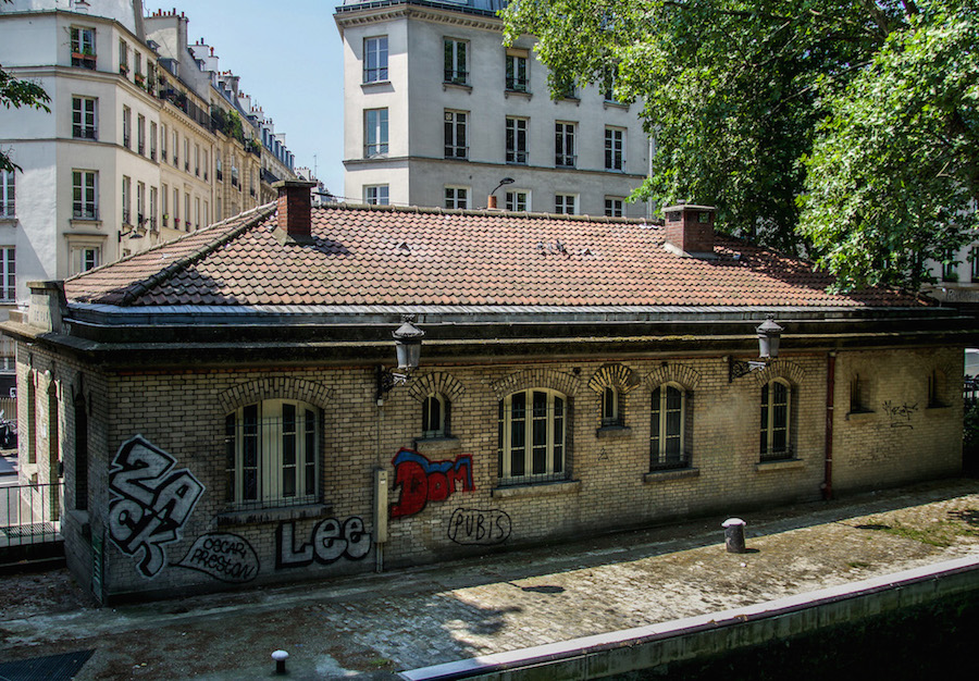 Brick building with graffiti by the canal, Paris 10