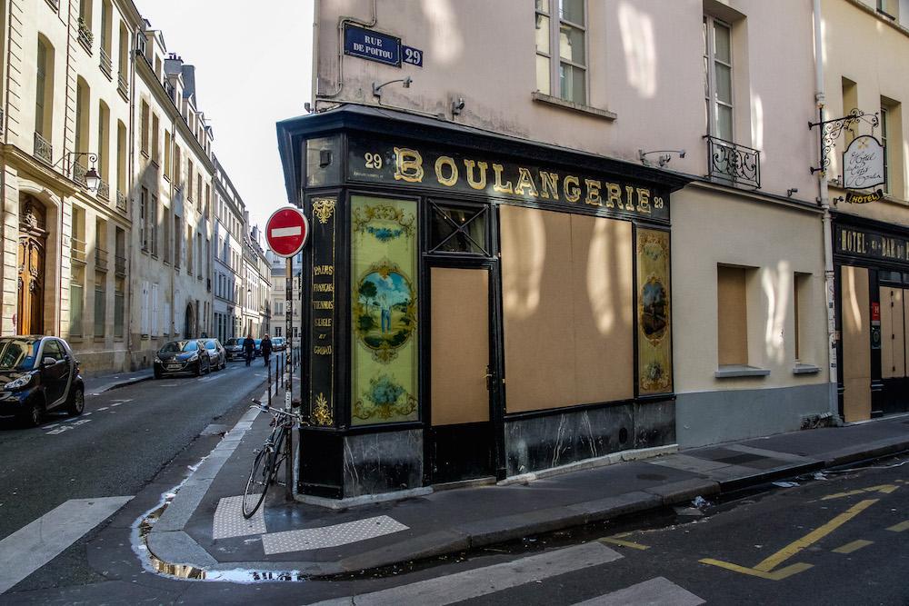 Paris during Coronavirus; some storefronts are boarded up as is this boulangerie