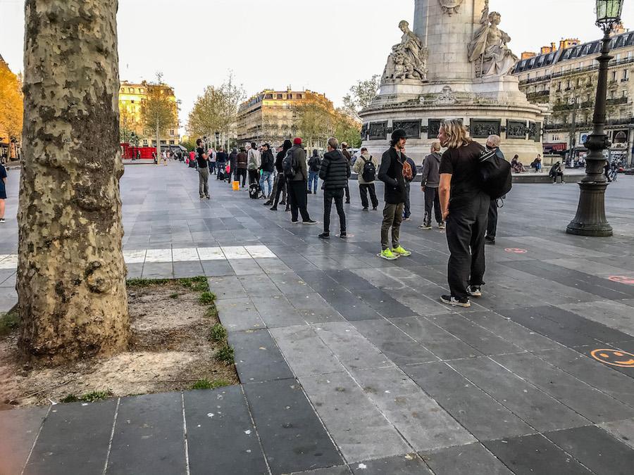 Paris during Coronavirus: A line up of people at Place de al République waiting for food 