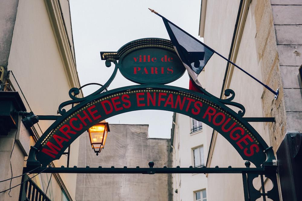 the green arched sign with red writing of marché des enfants rouges in Paris