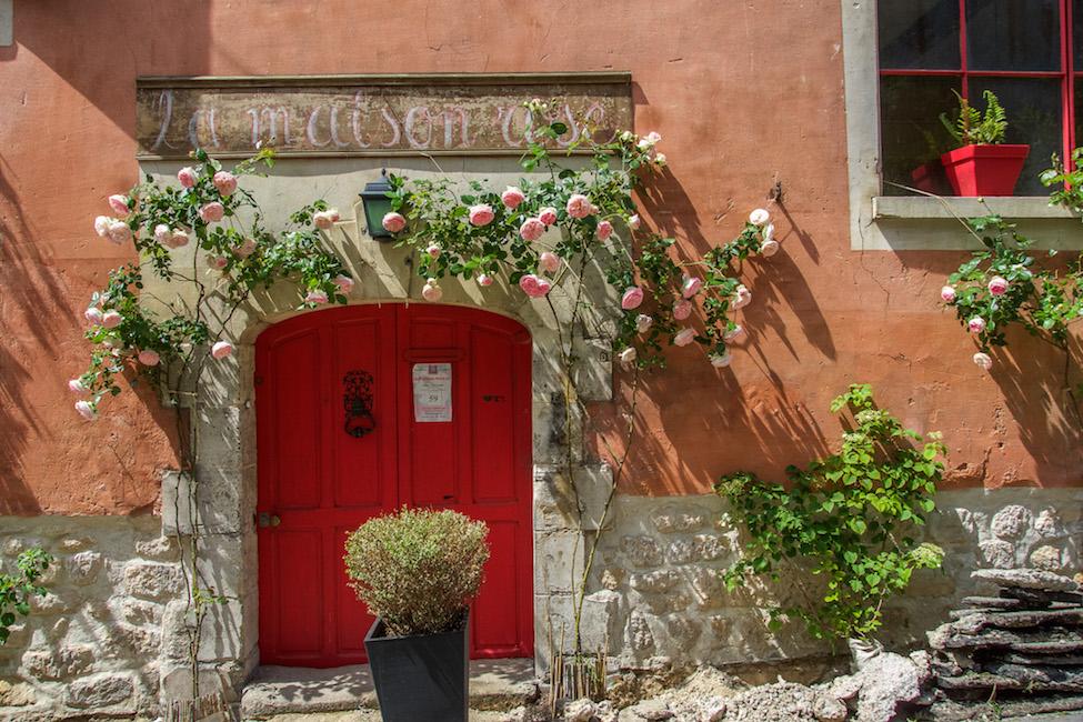 Salmon terra cotta and a red door framed by roses in Auvers-sur-Oise