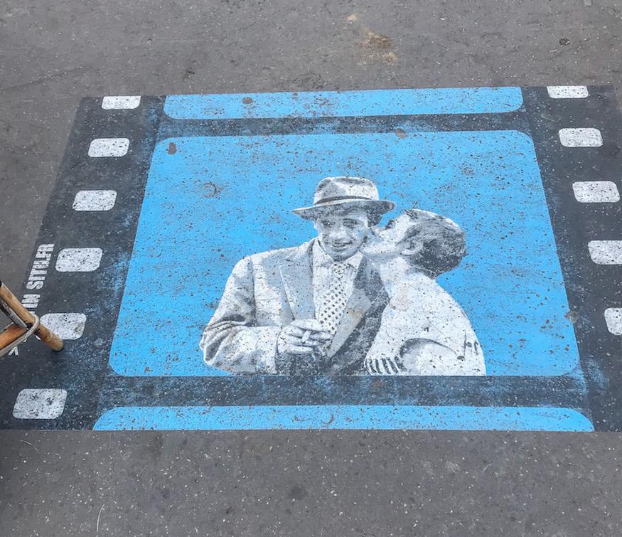 A scene from the movie Breathless painted on the sidewalk in the 14th arrondissement of Paris by the Raspail metro station