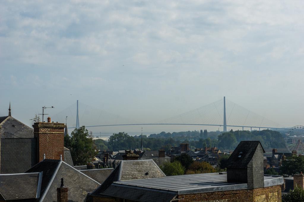 view over rooftops of the long bridge called the Normandie. Can see the cables