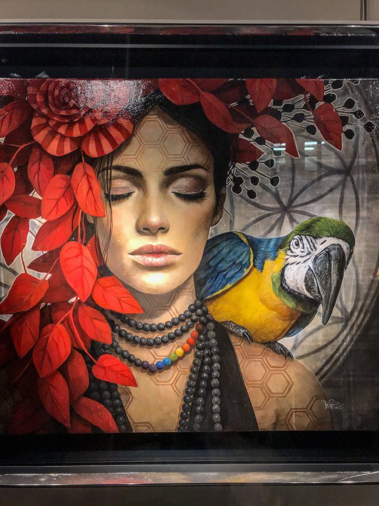portrait of a woman with a macaw and a red flowers