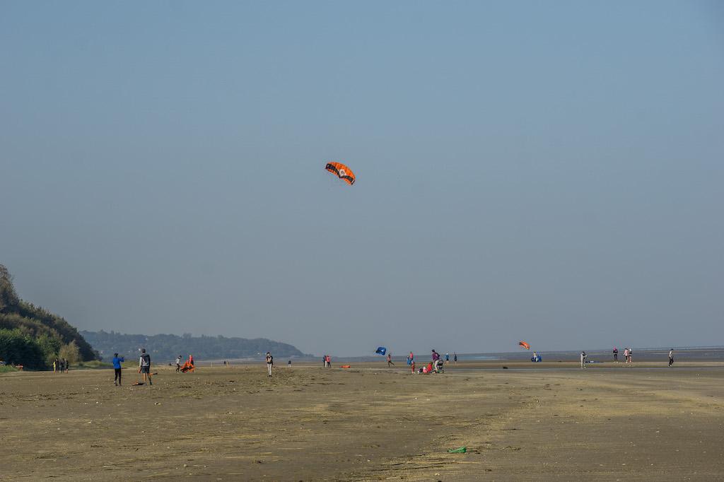 the sandy expanse of beach at Honfleur; kite sailors practicing with their sails 