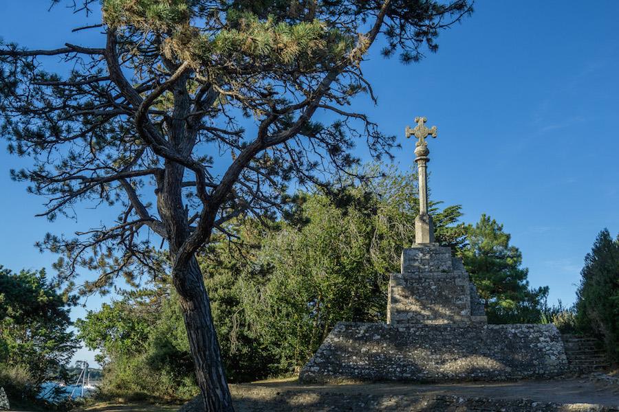 le Calvaire de Trec'h on ile aux Moines - this tall cross is mounted on a stone base and the backdrop is blue sky